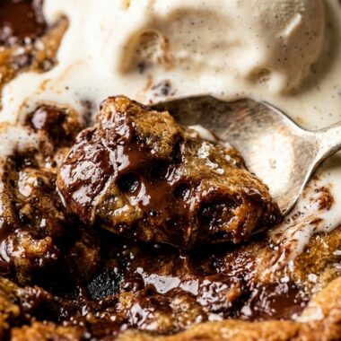 Ultra close-up macro of gooey brown butter chocolate chip skillet cookie with vanilla bean ice cream
