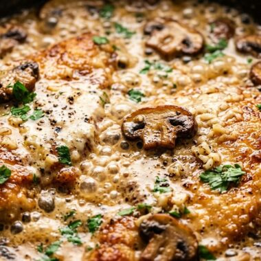 Ultra close-up macro of golden seared chicken cutlets simmering in velvety garlic parmesan mushroom cream sauce