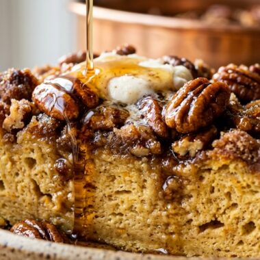 Ultra close-up macro of baked pumpkin spice brioche French toast with caramelized pecan streusel and maple syrup drip